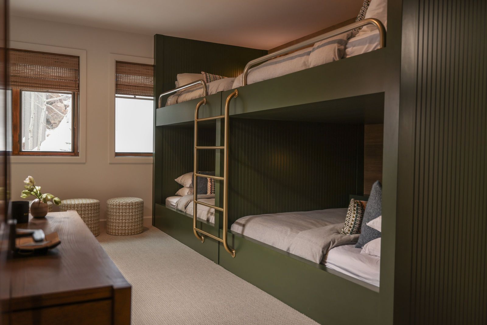 Custom forest-green queen bunk beds with brass ladders and reading sconces