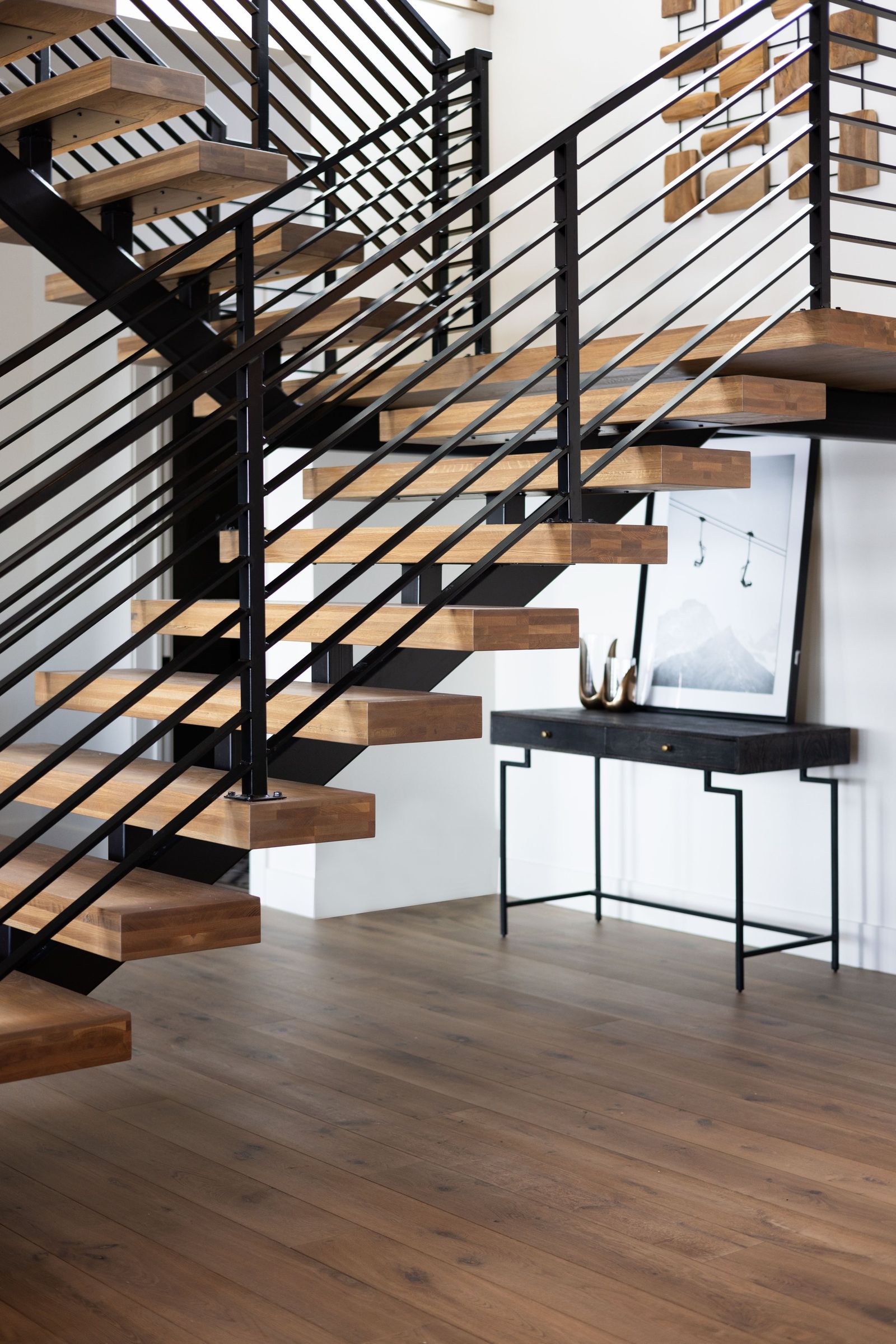 Floating white oak treads on a black steel stringer with horizontal rail
