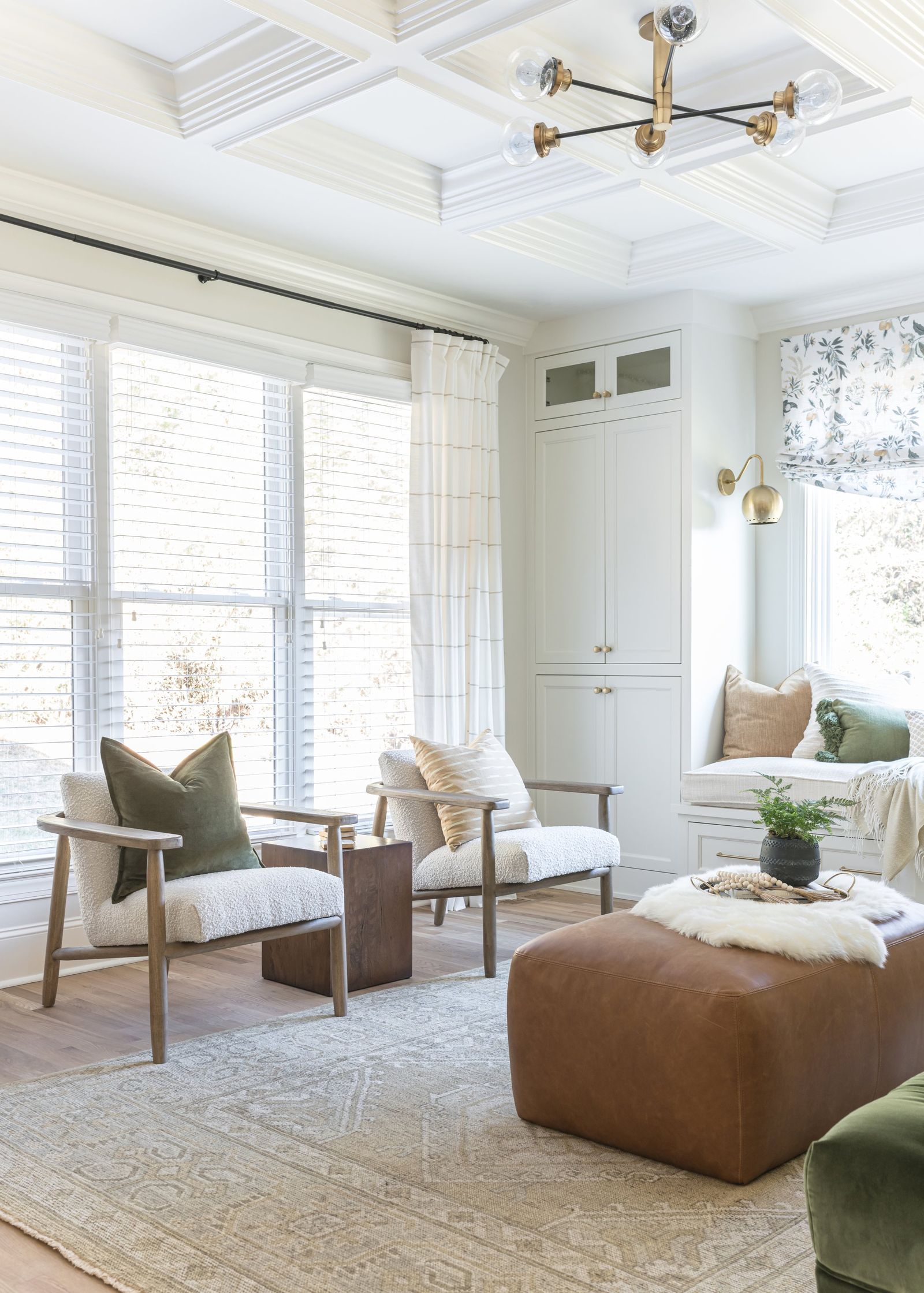 Pair of oak lounge chairs beside tall windows under a coffered ceiling