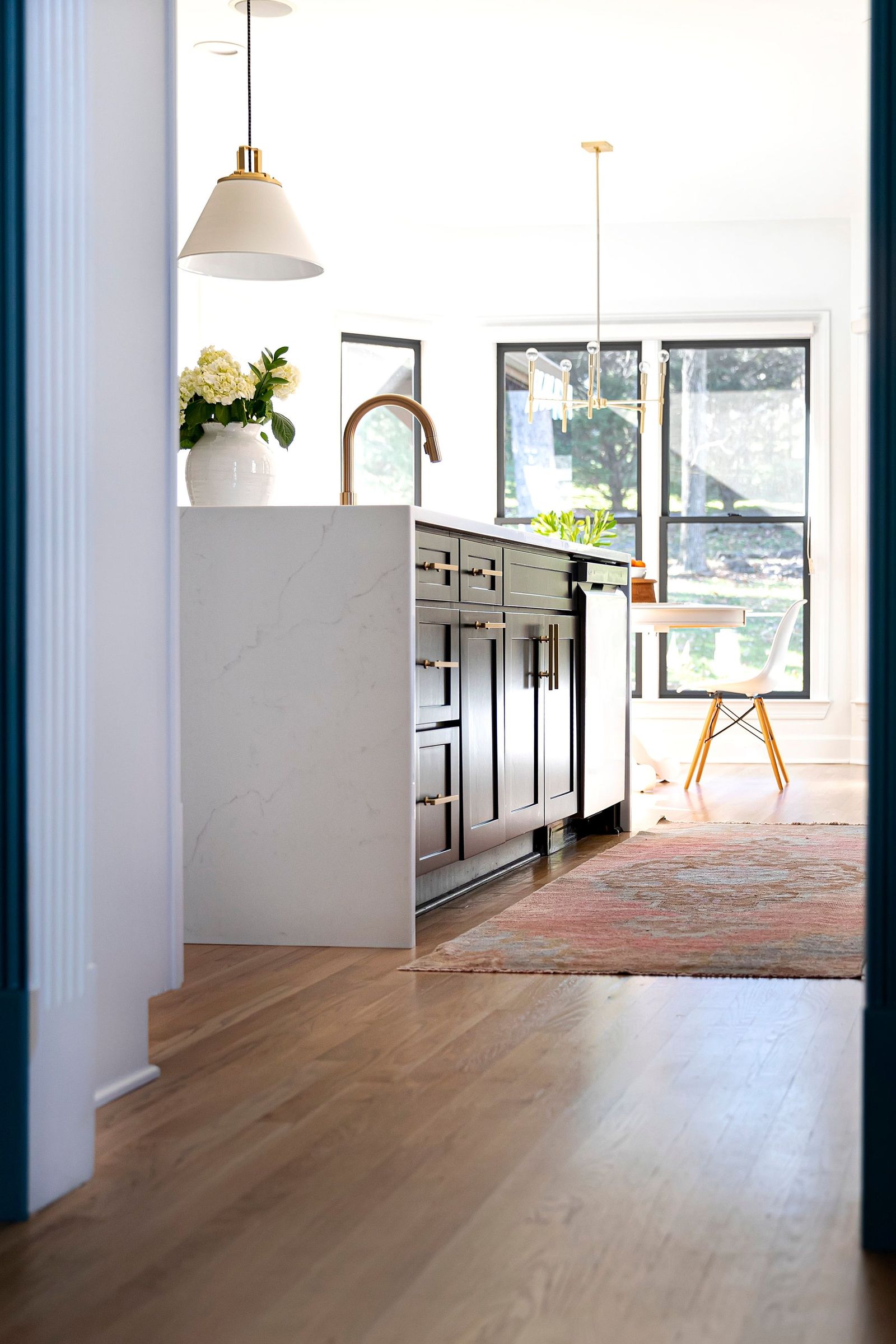 View through a doorway into the kitchen, past the waterfall island to the breakfast area