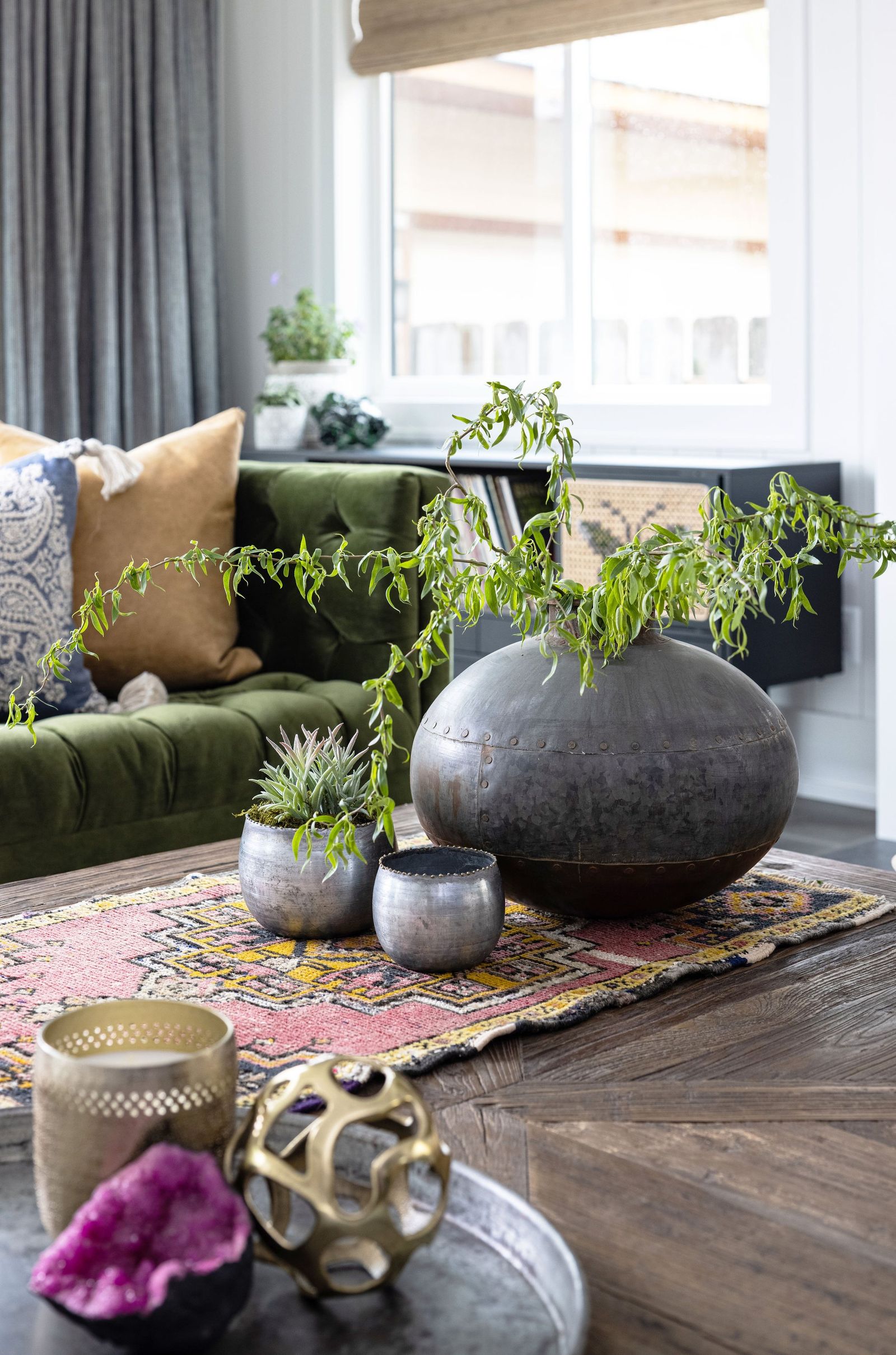 Coffee table styled with a black vase, succulents, a kilim runner and a geode