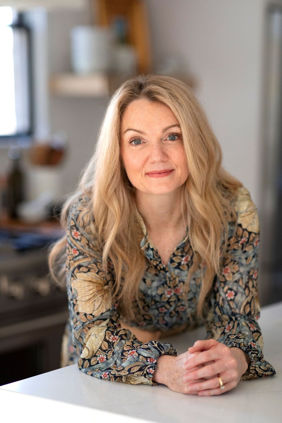 Close portrait of Joni Glass leaning on a kitchen counter
